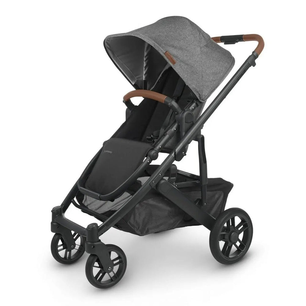 Uppababy Cruz V2 Stroller in gray canopy and black frame with brown faux-leather handlebar, ready to push.