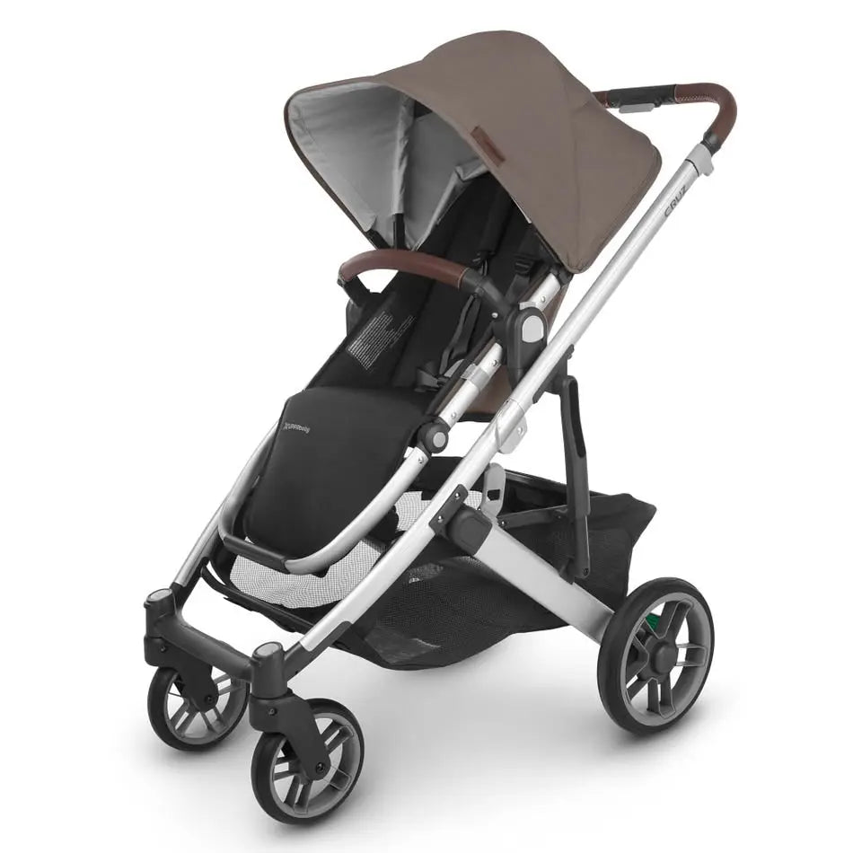 Uppababy Cruz V2 Stroller with brown canopy, silver frame, black seat, and roomy storage basket ready for a stroll