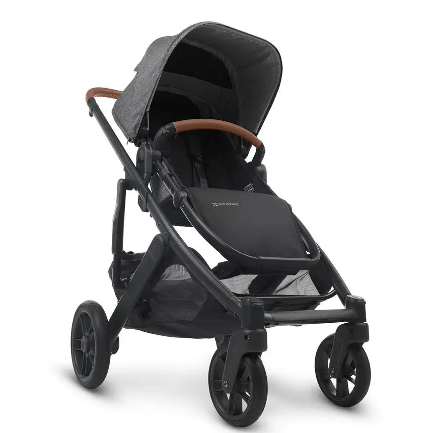 Uppababy Cruz V2 Stroller in black with brown faux-leather handlebar, canopy raised over a sturdy frame.