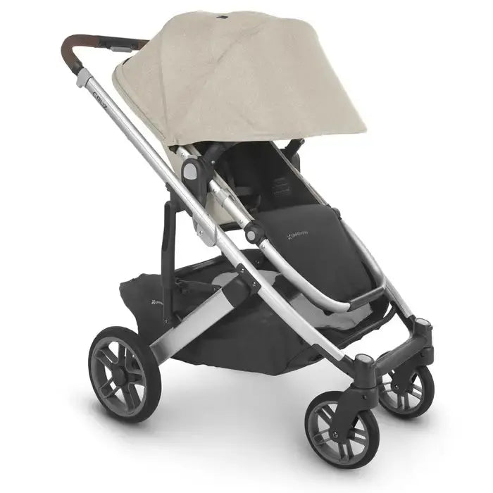 Uppababy Cruz V2 Stroller, beige canopy and silver frame, ready for a smooth push with large wheels.