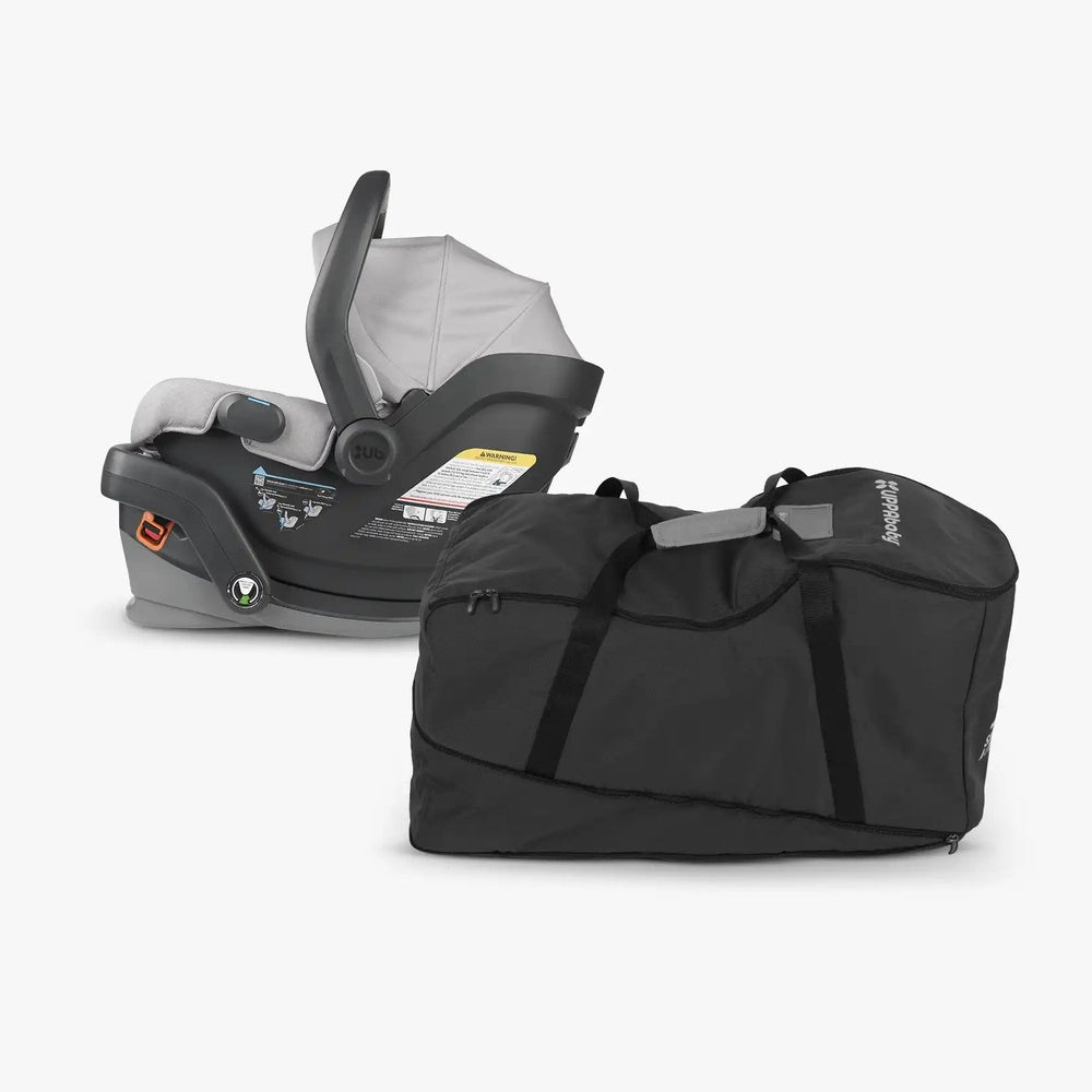 Uppababy Travel Bag For Mesa car seat, black fabric with carrying handles, shown beside the Mesa seat.