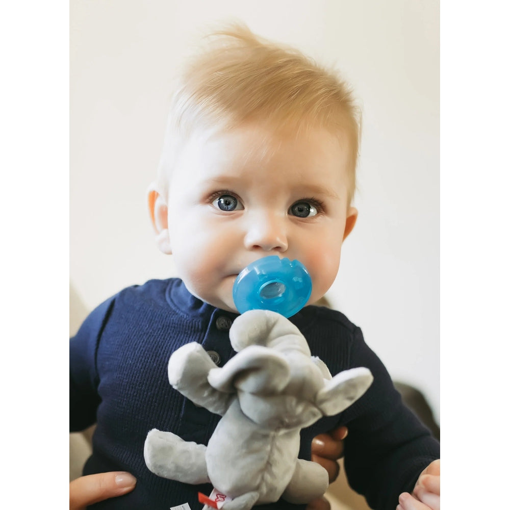 WubbaNub Infant Plush Toy Pacifier Grey Elephant; baby cuddles the blue pacifier attached to the soft grey plush.