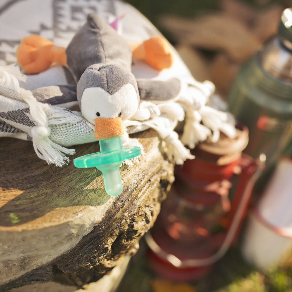 Wubbanub pacifier with gray penguin plush and green silicone nipple