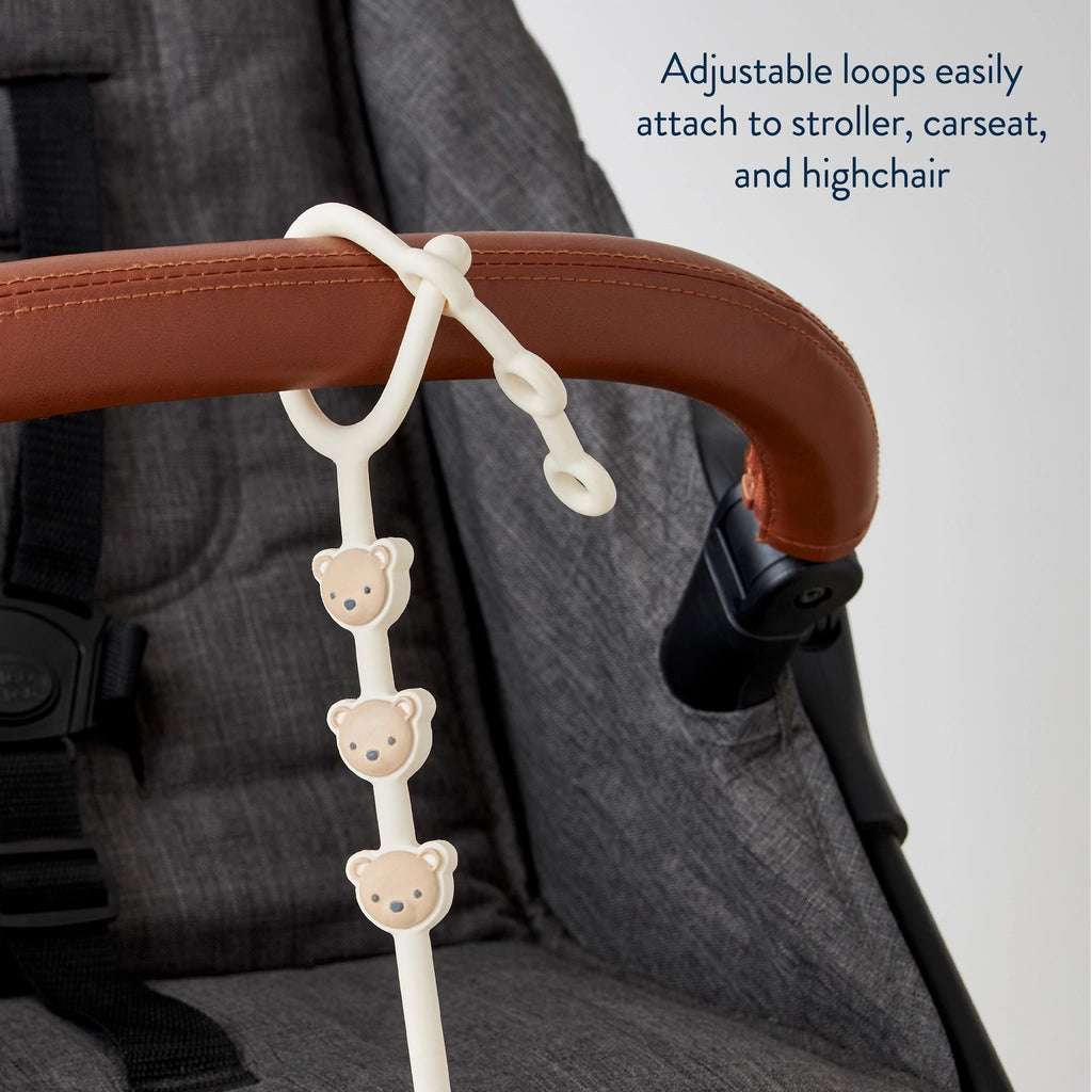 Itzy Ritzy Itzy Strap stroller toy with cream bear charm beads attached to a stroller handle