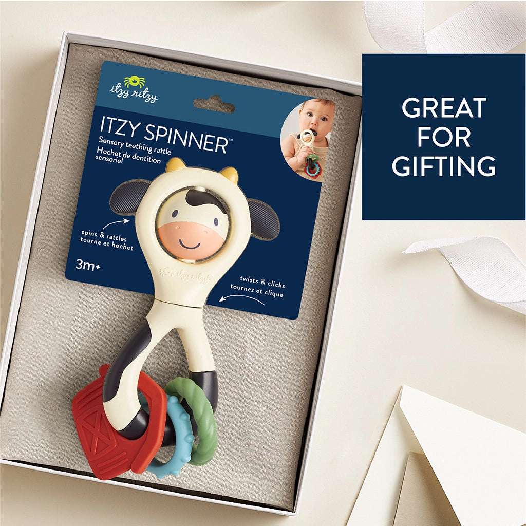 Itzy Ritzy Itzy Spinner toy; cream cow figure with multicolor rings