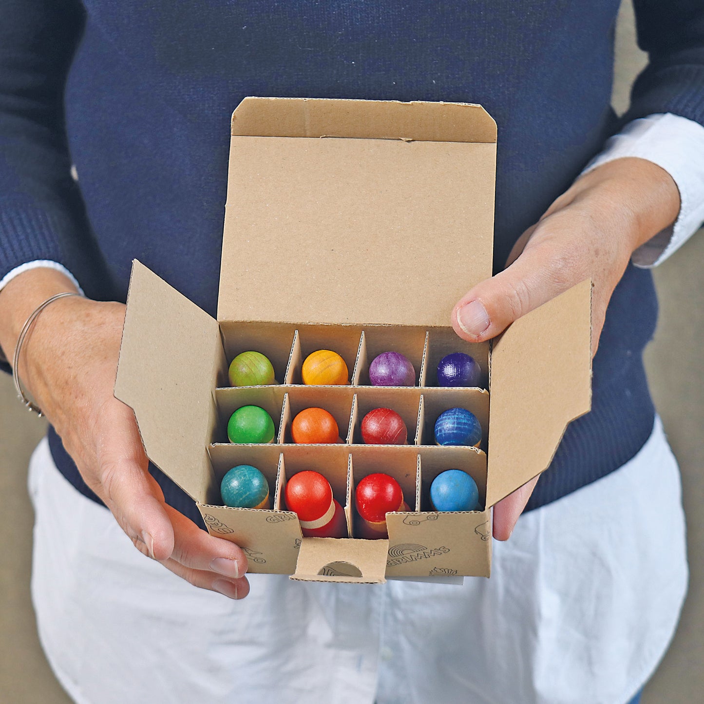 Grimm's 12 rainbow friends, colorful wooden beads in a cardboard box