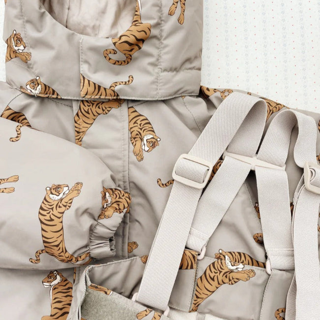 Konges Slojd Mismou Jacket Tiger Oak, beige tiger-print puffer shown with attached carrier straps.
