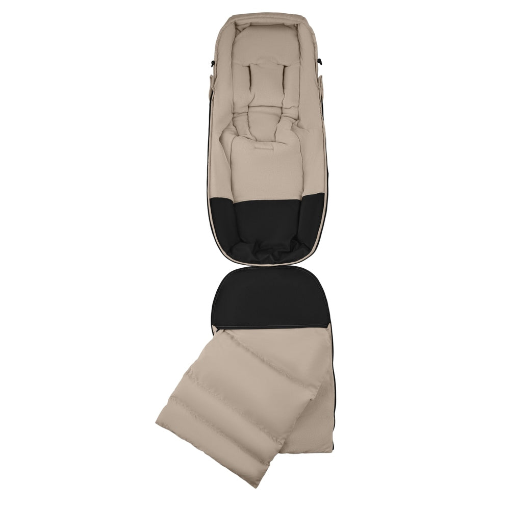 Bugaboo THERMOLITE® Performance Footmuff in beige with black lining, opened to show quilted warmth for cold strolls.