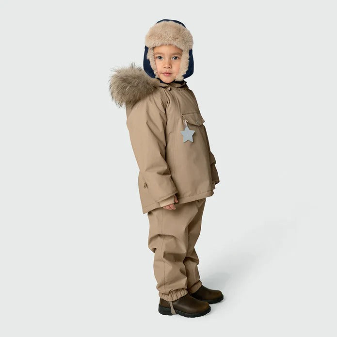 MINI A TURE Matcrister Teddy Lined Winter Hood Outer Space toddler outfit in tan, fur-trimmed hood, star badge, as child stands.