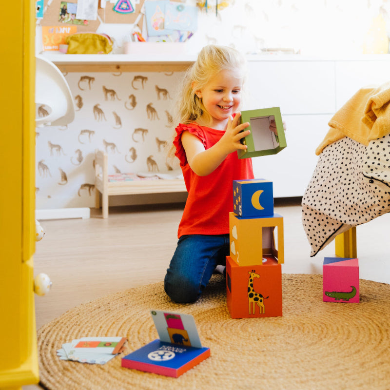 Smart Games Peek-A-Zoo, child stacking five colorful blocks